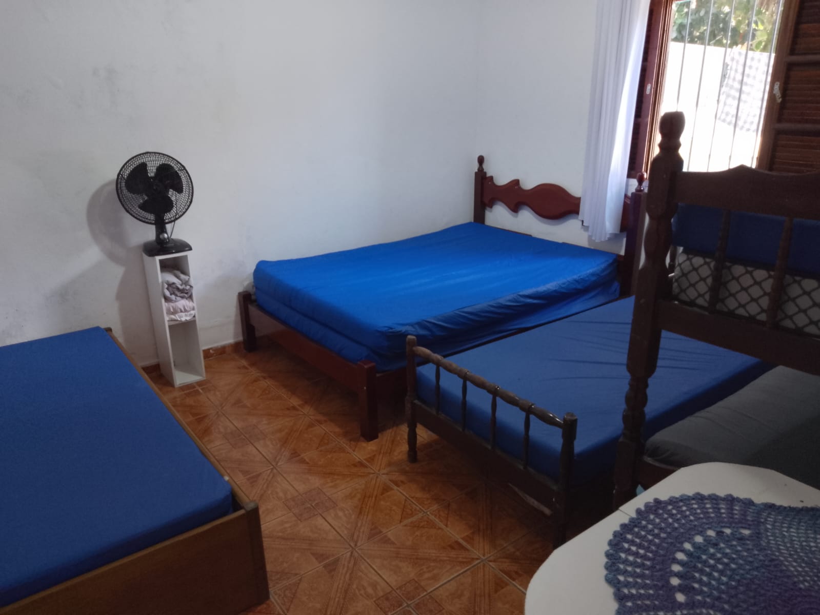 Quarto com cama de casal e ventilador