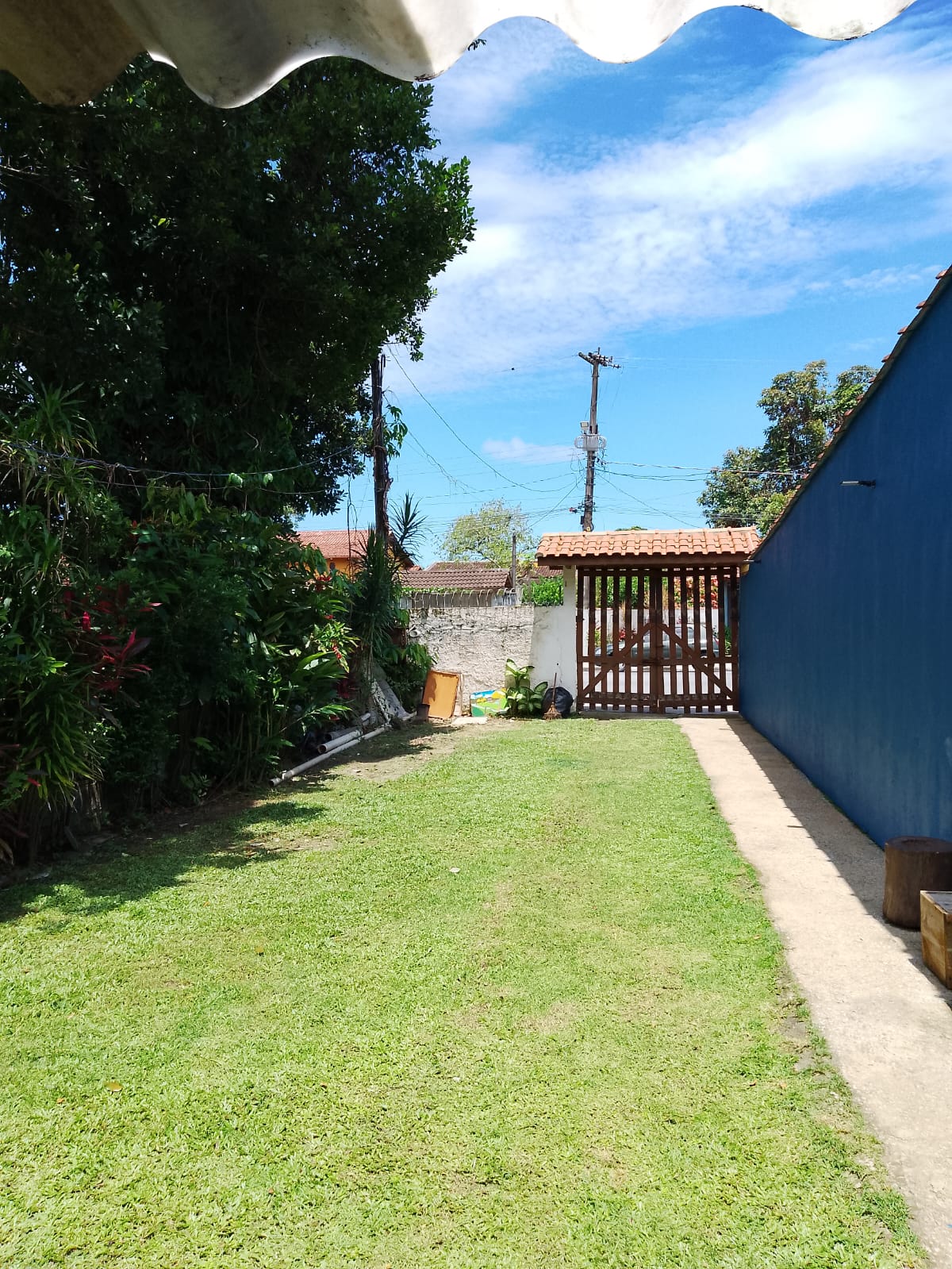 Quintal com gramado e portão de madeira